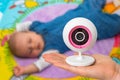 Mother is holding baby monitor camera for safety of her baby Royalty Free Stock Photo