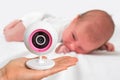 Mother is holding baby monitor camera for safety of her baby Royalty Free Stock Photo