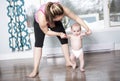 Mother holding a baby under his arms in living room Royalty Free Stock Photo