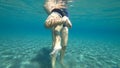 Mother holding baby in the water, boy tries to swim in the sea. Boy actively moves his legs in the water