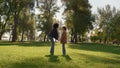 Mother holding daughter hands gently touching noses on sunny green park field. Royalty Free Stock Photo