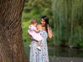 Mother holding daughter next to tree Royalty Free Stock Photo