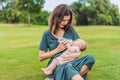Mother holding and feeding baby from milk bottle in the park. Portrait of cute newborn baby being fed by her mother Royalty Free Stock Photo