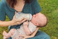 Mother holding and feeding baby from milk bottle in the park. Portrait of cute newborn baby being fed by her mother Royalty Free Stock Photo