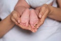 Mother holding feet of her cute little baby in hands Royalty Free Stock Photo
