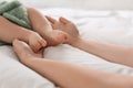 Mother holding feet of her little baby on bed Royalty Free Stock Photo