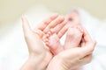 Mother holding feet of newborn baby. Infant legs in parent hand. Child support and care. Happy family Royalty Free Stock Photo