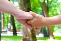 Mother holding a hand of her child`s on the road in the park, Cl