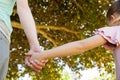 Mother holding a hand of her daughter outdoors