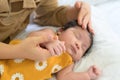 Mother holding hand of newborn baby on white bed.Mom lying down nursing infant girl at home Royalty Free Stock Photo