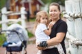 Mother holding hands her heavy two years old daughter, woman love to her child, countryside portrait Royalty Free Stock Photo