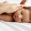Mother holding head of baby In the safe hands. Mother's Care. Mom's Hand Stroking Sleeping Baby's Royalty Free Stock Photo