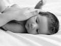 Mother holding head of baby In the safe hands. Mother's Care. Mom's Hand Stroking Sleeping Baby's Royalty Free Stock Photo