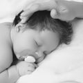 Mother holding head of baby In the safe hands. Mother& x27;s Care. Mom& x27;s Hand Stroking Sleeping Baby& x27;s Royalty Free Stock Photo