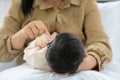 Mother holding head of her newborn baby in hand. Loving mum hand holding sleeping infant child on bed Royalty Free Stock Photo