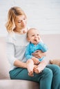 mother holding her adorable child on knees while sitting