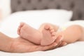 Mother holding her baby`s feet on bed Royalty Free Stock Photo