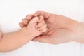 Mother holding her baby`s hand on bed Royalty Free Stock Photo