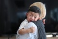 Mother holding her crying son living room at home. Royalty Free Stock Photo