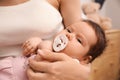 Mother holding her cute little baby with pacifier at home, closeup Royalty Free Stock Photo