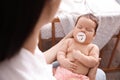 Mother holding her cute little baby with pacifier at home, closeup Royalty Free Stock Photo