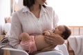 Mother holding her cute little baby with pacifier at home, closeup Royalty Free Stock Photo