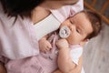 Mother holding her cute little baby with pacifier indoors, above view Royalty Free Stock Photo