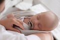 Mother holding cute sleeping baby with pacifier, above view Royalty Free Stock Photo