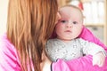 Mother holding her infant baby son, kissing him on face from side Royalty Free Stock Photo