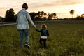 A mother holding her little daughter`s hand in the field Royalty Free Stock Photo