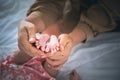 mother holding her one-month-old daughter's tiny feet in her palms with love and protect Royalty Free Stock Photo