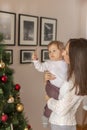 Mother holding her son and decorating Christmas tree Royalty Free Stock Photo