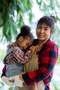 Mother holding his Daughter in her arms looking at her with love in vegetable garden. Happy loving mother holding daughter and lau Royalty Free Stock Photo