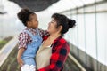 Mother holding his Daughter in her arms looking at her with love in vegetable garden. Happy loving mother holding daughter and lau Royalty Free Stock Photo