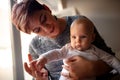 Mother holding and hugging her cute baby -Child claps his hands. Royalty Free Stock Photo