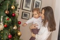 Mother holding her son and decorating Christmas tree Royalty Free Stock Photo