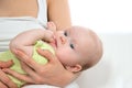 Mother holding infant child baby girl lying on her hands