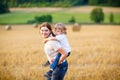 Mother holding kid boy on arms on wheat field in summer Royalty Free Stock Photo