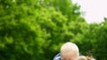 Mother holding and kissing her one year old son in park