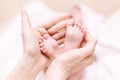 Mother holding newborn baby feet in hands. Mom taking care about infant child after taking bath. Parents childcare. Children Royalty Free Stock Photo