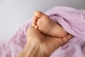 Mother holding newborn baby foot, adorable tiny toes