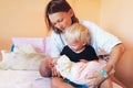 Mother holding newborn baby with older child in hospital. Royalty Free Stock Photo