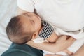 Mother holding newborn baby sleeping in her arm on bed Royalty Free Stock Photo