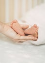 Mother holding newborn baby& x27;s feet in her hand. Vertical orientation Royalty Free Stock Photo