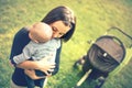 Mother holding newborn son in hands. Loving mother hand holding cute sleeping newborn baby child in park at sunset Royalty Free Stock Photo