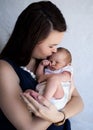 Mother holding sleeping newborn baby kissing his forehead Royalty Free Stock Photo