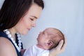 Mother holding sleeping newborn baby up to her face looking at him Royalty Free Stock Photo