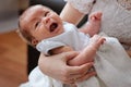 Mother holding and trying to calm her newborn crying baby