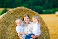 Mother holding two children on arms on wheat field in summer Royalty Free Stock Photo