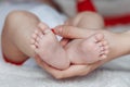 Mother holds baby feet in hands Royalty Free Stock Photo